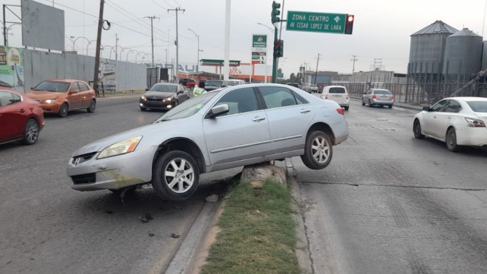 Se sube auto en camellón queda atorado.