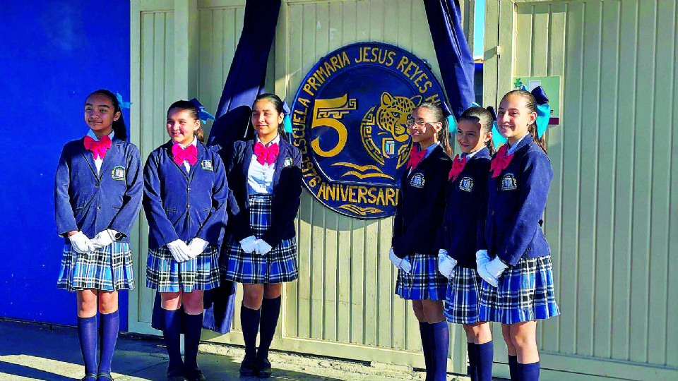 Las alumnas de la escolta posaron orgullosas ante el símbolo por el 50 aniversario de la institución.